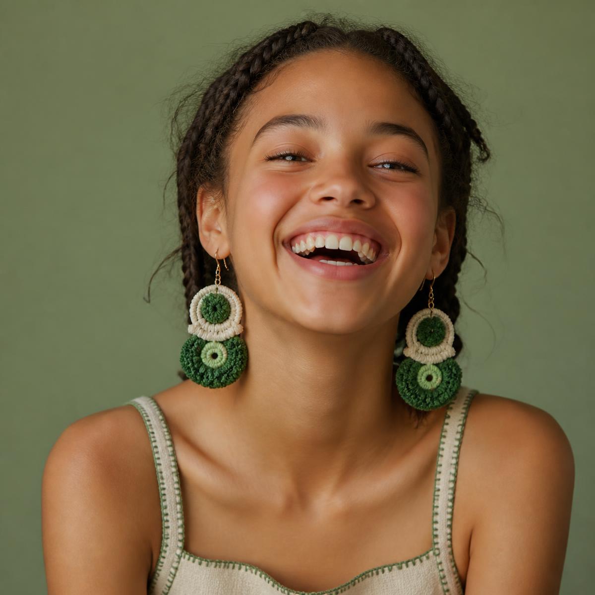 Nour lacht, met groene en crèmekleurige oorbellen